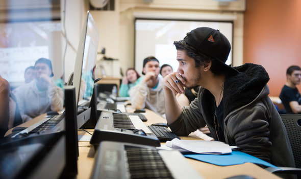 students in a music class sitting at keyboards and looking at computers