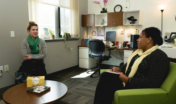 Two people sitting in chairs and talking