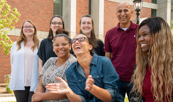 The Academic Achievement Center staff laughing during a photoshoot outside the Rondileau Student Union