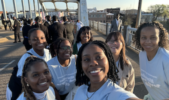 6 female students stand on the Edmund Pettus Bridge in Selma Alabama on day 1 of Alternative Break