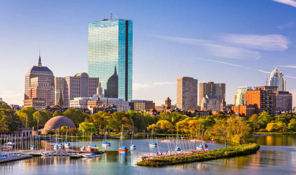 Boston skyline on a sunny day with Charles River in foreground and blue sky background