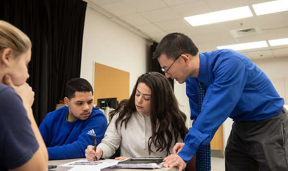 Dr. Tom Wu working with students in a kinesiology class