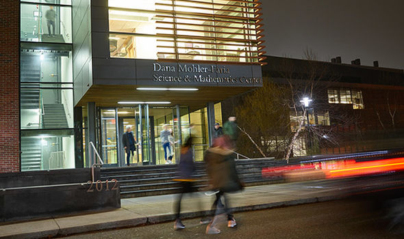 exterior photo of BSU's Dana Mohler-Faria Math and Science Center in the evening with people inside and outside of building
