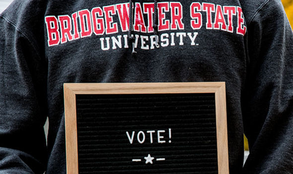A person in a BSU sweatshirt holding a letter board that says VOTE