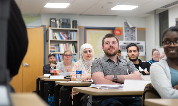 A classroom of graduate students looking at the professor