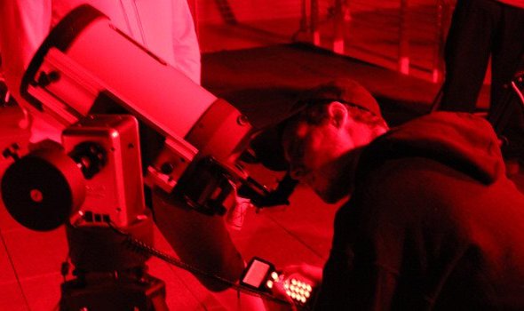 student looking into telescope