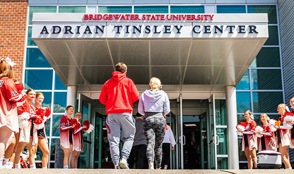 Admitted students walking into the Tinsley Center, with cheerleaders on either side