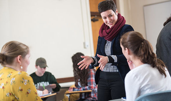 Dr. Sarah Wiggins talks to students who are working in pairs in class