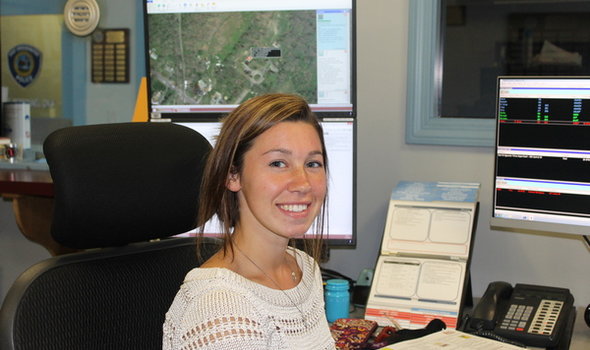 BSU female student interning with local police department shown at dispatch desk