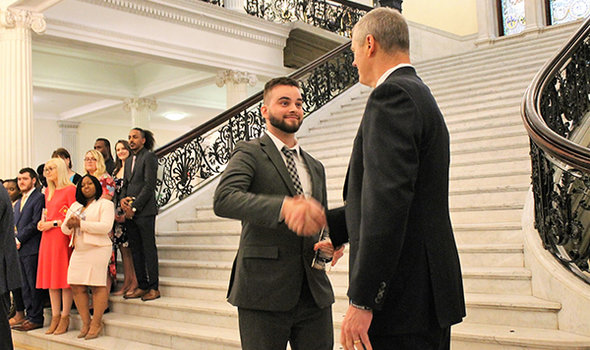 BSU student shaking Governor Charlie Baker's hand at the Massachusetts state house