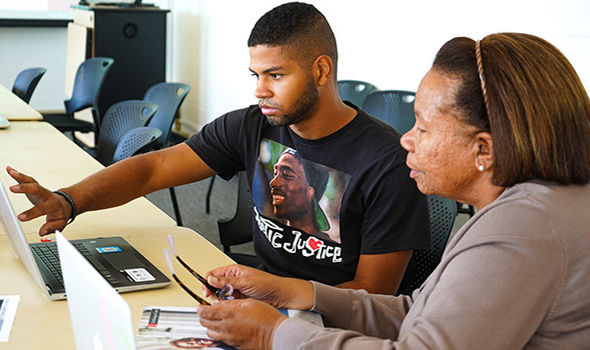 BSU Director of Internships, Diane Bell, works with a student who points to something on a laptop