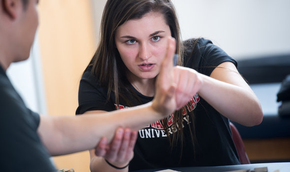 a student examining another student's hand in class