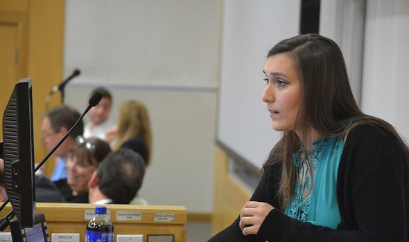 student giving presentation at podium with computer