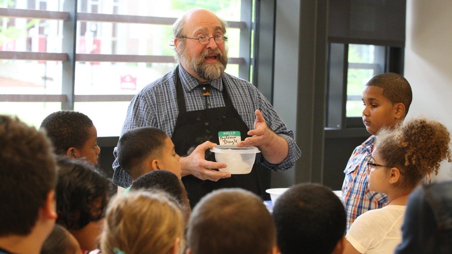 professor surrounded by children