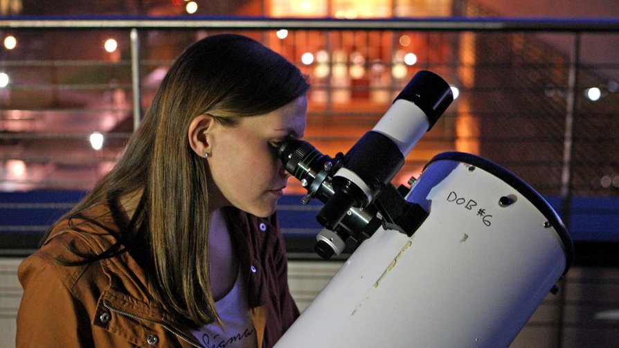 woman looking into a telescope