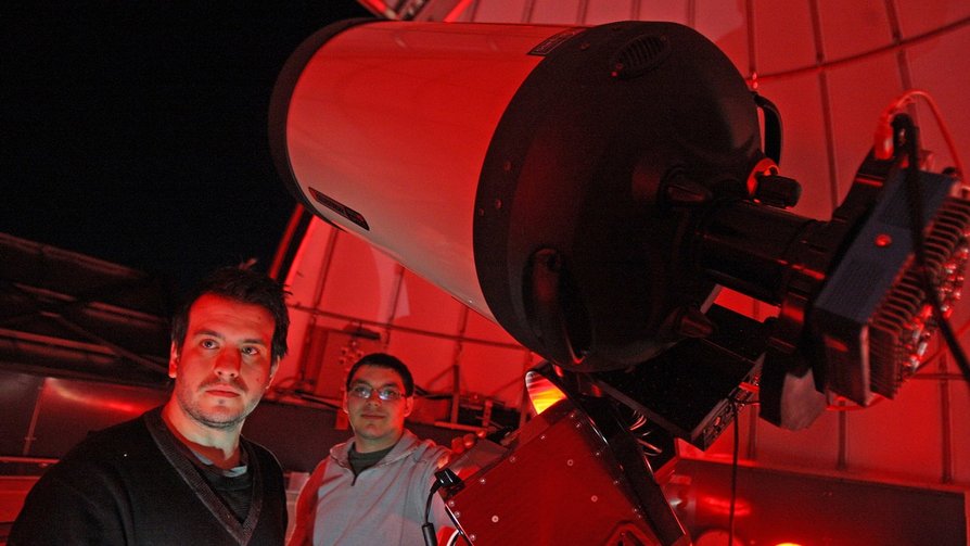 students inside observatory with large telescope
