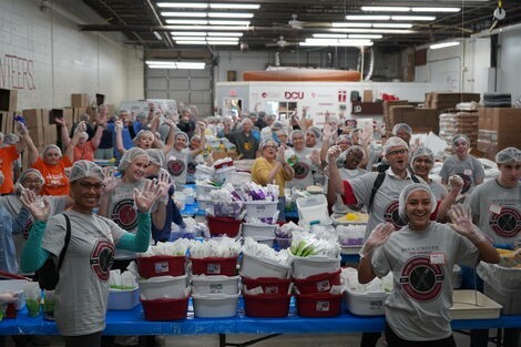 A group of people put together boxes of food 