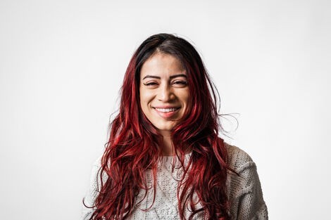 A woman with long hair smiles at the camera 