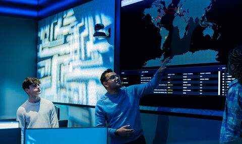 A student watches a faculty member demonstrate the features of BSU's cyber range