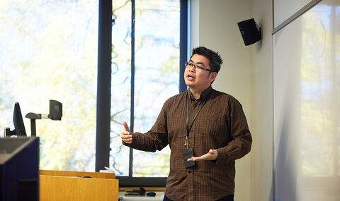 Dr. Cory Yeo lecturing in front of a whiteboard