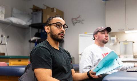2 graduate students in class sitting at a padded table
