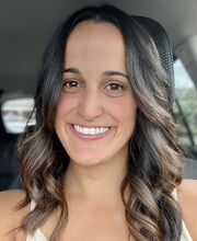 Anabel Graham smiling with long brown hair and wearing a v-neck sleeveless top