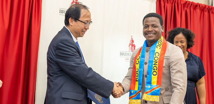 A Mandela fellow shakes hands with a BSU administrator.