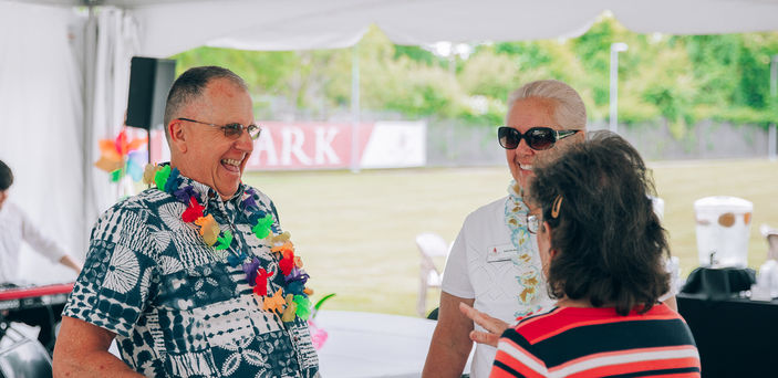 Three people converse at a Senior College event.