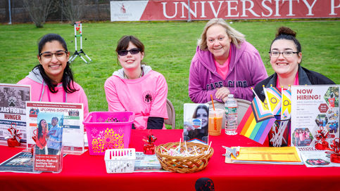 four students sit at a table in university park at SAS's BeSeen event