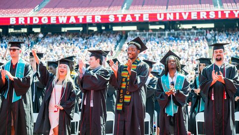 Diverse group of students clapping and cheering at the Bridgewater State University graduation
