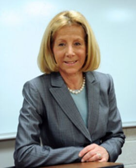 Dr. Phyllis Gimbel at the podium in a classroom