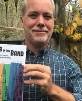 Matt Bell holding a copy of the book The Boys in the Band