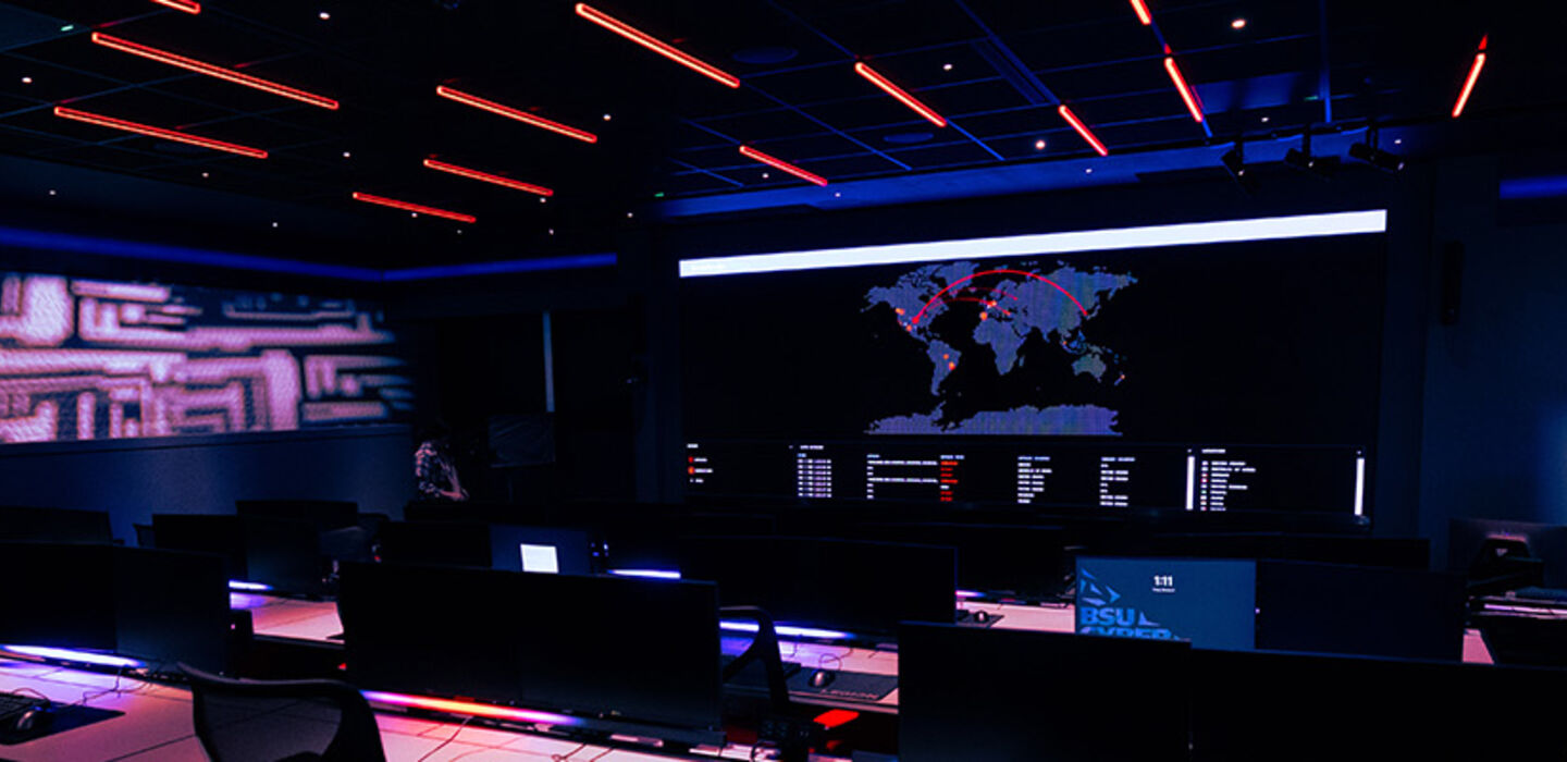 A view of the new BSU cyber range - rows of computer workstations with purple and red mood lighting