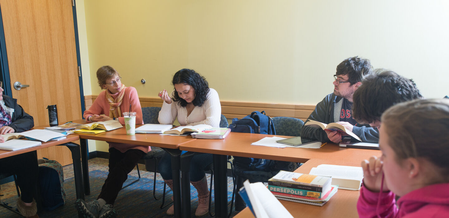 Dr. Maggie Lowe teaches a history class sitting with students at an open square table